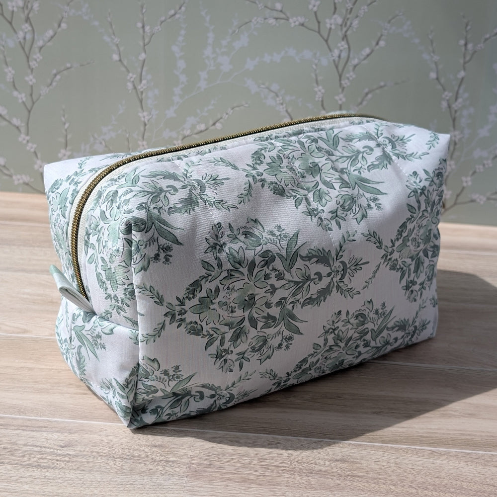 Floral-patterned toiletry bag on a wooden surface with a light background