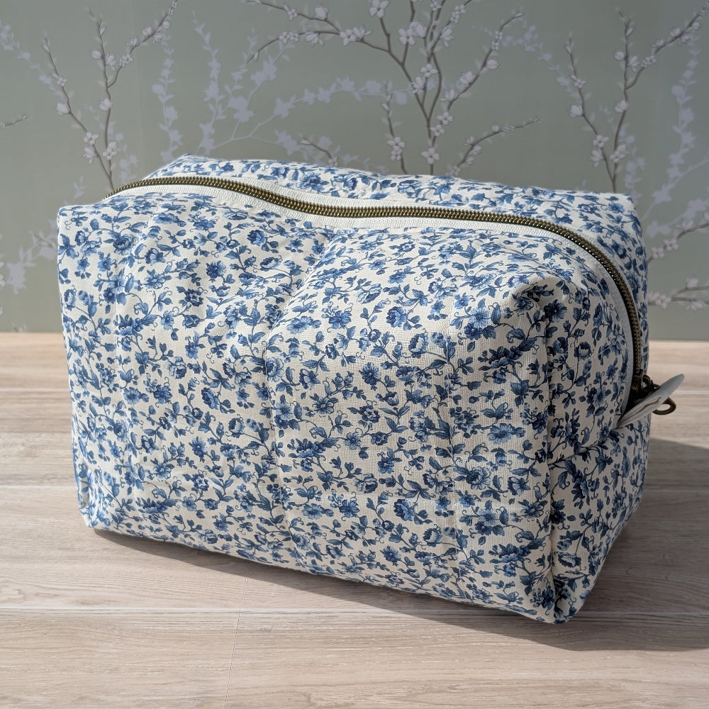 Floral-patterned toiletry bag on a wooden surface with a neutral background
