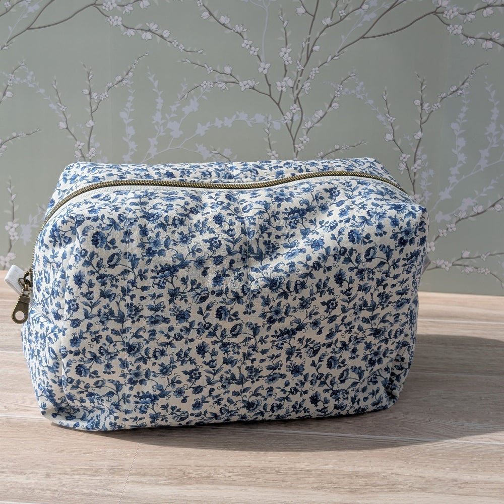 Floral-patterned toiletry bag on a wooden surface with a light gray background