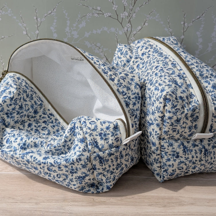 Two floral-patterned bags on a wooden surface with a neutral background