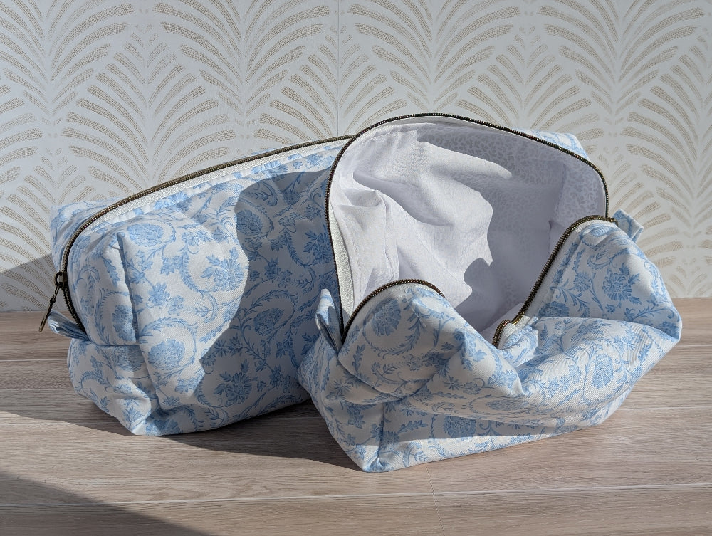 Blue floral-patterned travel bag on a wooden surface with a light background