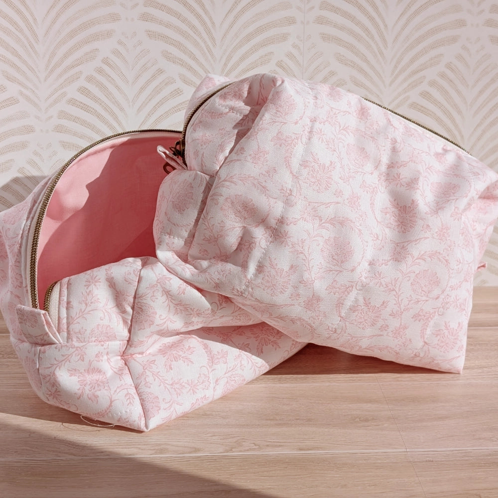 Pink floral-patterned makeup bag on a wooden surface with a light background