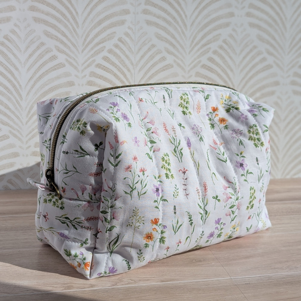 Floral-patterned makeup bag on a wooden surface with a light background