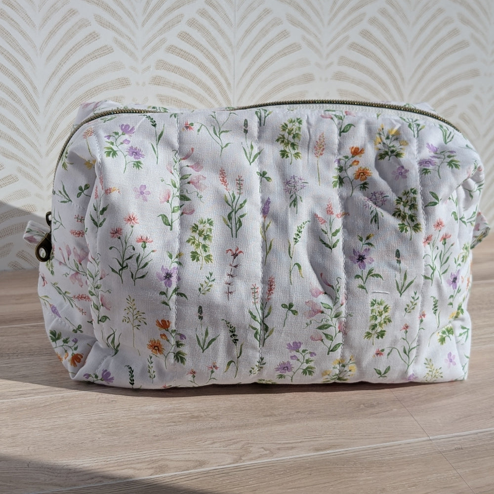 Floral-patterned pouch on a wooden surface with a light background