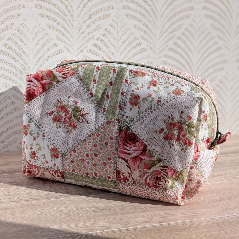 Floral patchwork makeup bag on a wooden surface with a patterned wall background