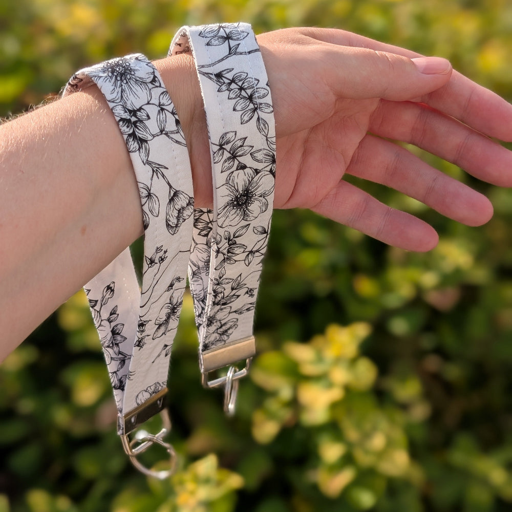 Floral-patterned strap on a wrist with a blurred green background