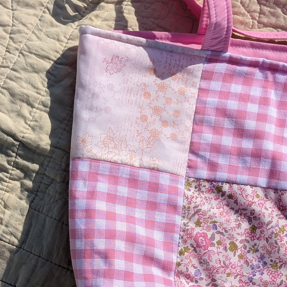 Patchwork quilt with pink and white checkered pattern on a textured surface