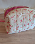 Floral-patterned cosmetic bag on a wooden surface